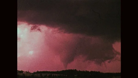 1970s: Tornado forms from storm clouds. Calm clouds on horizon. Stock Footage 121588180