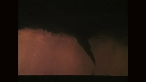 1970s: Tornado forms from storm clouds. Tornador forming from clouds above Stock Footage 121588188