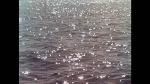 1970s: Tracking shot of ocean surface. Bottle floating in water. View of buoy. Stock Footage 97198023