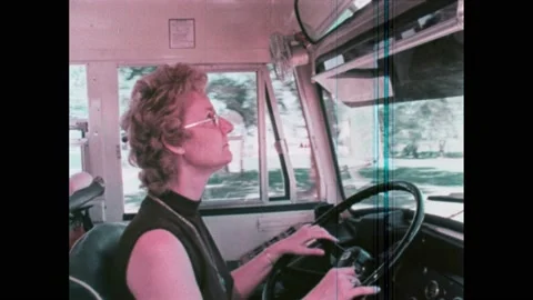 1970s: A train pulls around the tracks. Woman drives school bus, looks in Stock Footage 224312633