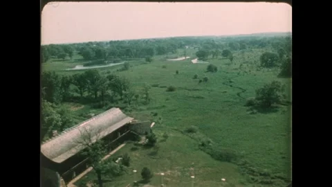 1970s: trees and grassy fields and agricultural fields, farm building, ponds, Vídeos de archivo 261568326