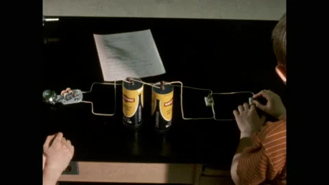 1970s: Two boys close a switch on a parallel circuit. Assignment on a Video stock 163453340