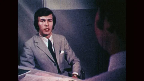 1970s: Two men engage in a professional office interview, exchanging a tape and Stock Footage 89040467