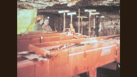 1970s: Two mine workers inside mine stand behind machine, talk. Mine worker Stock Footage 79463938