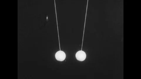 1970s: Two rods, one amber and one glass, are shown alongside two balls, one Stock Footage 75141697