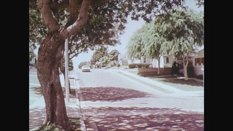 1970s: UNITED STATES: car drives down hill. Police motorbikes chase car along Stock Footage