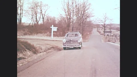 1970s: UNITED STATES: front view of car on road. Car stops on road. Children run Stock Footage