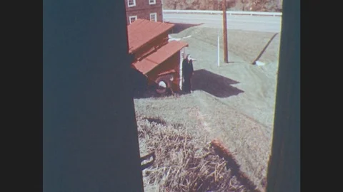 1970s: United States: Man Walks In Garden. View Of Man From Upstairs Window. Man Stock Footage