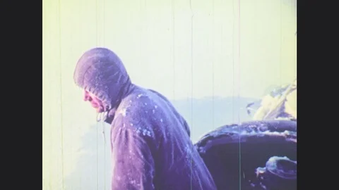 1970s: UNITED STATES: men dig ice from roof of submarine. View across ice and Stock Footage