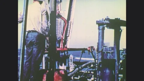 1970s: UNITED STATES: ships at sea. Diver welds metal underwater. Ship by oil Stock Footage