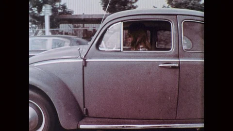 1970s: UNITED STATES: side profile of girl in car. Girl drives car. Front view Stock Footage 92862129