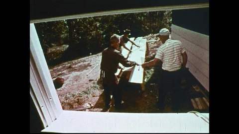 1970s: View through window, men with lumber / Close up of man / Close up of man. Video stock 74911449