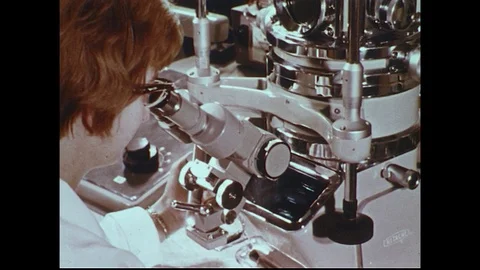 1970s: Woman looks through microscope / Close up of factory equipment / Thread Stock Footage