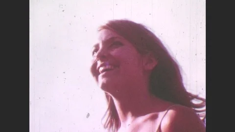 1970s: Woman smiles, laughs, tosses hair. Man and woman in bathing suits Stock Footage
