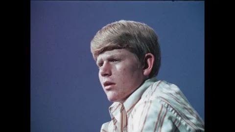 1970s: Young man sits at table.  Little boy shoves food in mouth.  Garbage Stock Footage 261243251