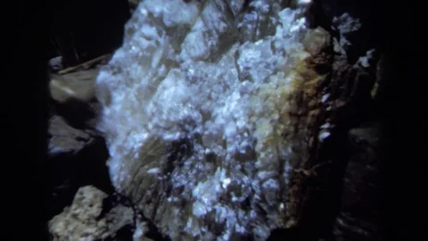 1971: Light Reflects Off Uneven White Crystal Facets Inside Dark Rock Shell Stock Footage 70535332