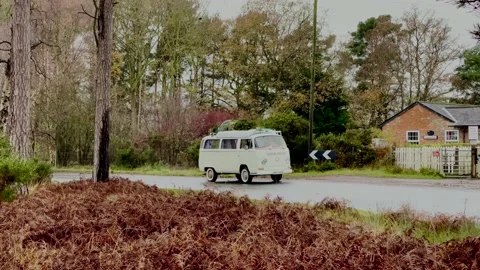 1972 Bay Window VW Campervan pulling onto road and driving past camera Stock Footage 144555860