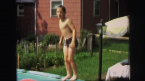 1972: boy jumping into above-ground pool LYNBROOK, NEW YORK Stock Footage