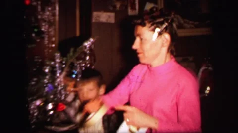 1972: christmas tree is seen with child opening presents LYNBROOK, NEW YORK Stock Footage