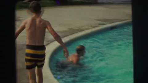 1974: childrens are playing in a swimming pool and a boy jumps to swim LYNBROOK, Stock Footage