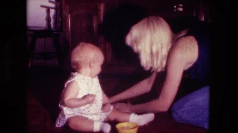 1974: mom is collecting mess from little girl FORT WAYNE, INDIANA Stock Footage