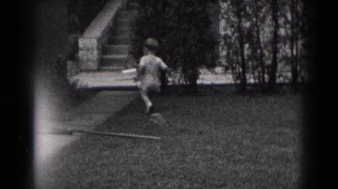 1975:MIDDLETOWN PA.Toddler Walking Around Pulling A Pull String Toy In Grass Foto stock