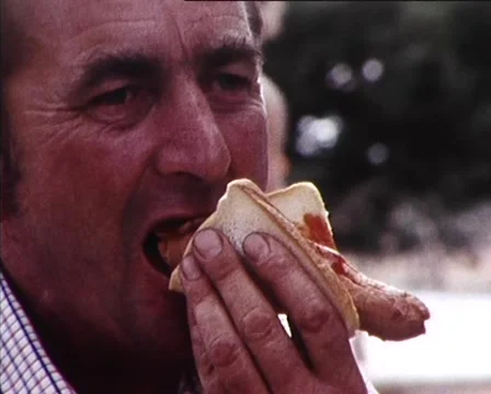1980: Man Eats Sausage and Fair Ground Scenes Stock-Footage 59997181