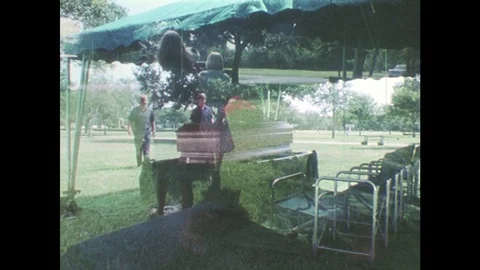 1980s: Cemetery officials take flowers off of casket. Cemetery workers prepare Stock Footage
