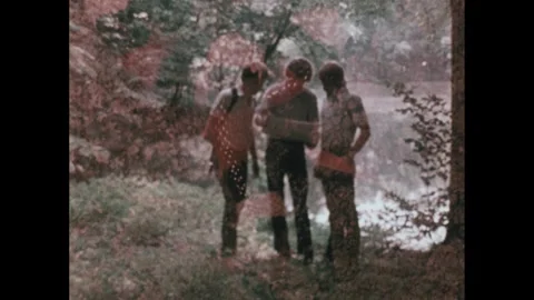 1980s: Close up of snake. Men in forest looking at map. Man steps over log. Man Stock Footage 279490497