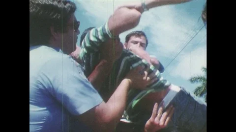1980s: Emergency workers pull a lifeless teenager from a car. Paramedics place Video stock 77846772