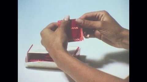 1980s: Hands gently open condom packet, remove condom. Instruction number two Stock Footage 81289306