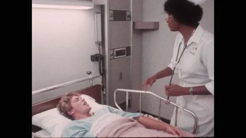 1980s: Nurse checking on patient in bed. Doctor watching patient lift weights in Video stock 220810838
