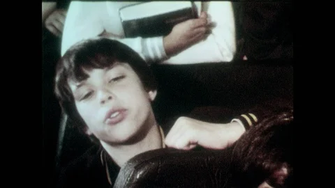 1980s: School bus, boy asks question. Driver turns around, leans on seats, talks Stock Footage 94465051