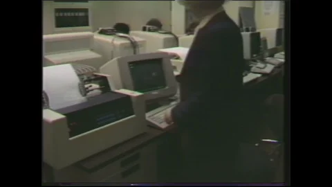 1980s: supervisor sitting at computer then logging off Video stock 129853017