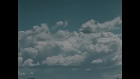 1980s: Time lapse of the changing clouds. The snowy trees, a snowman in a hat Stock Footage 249614756