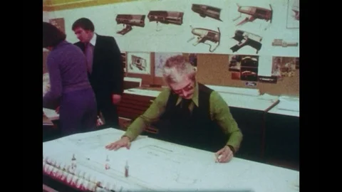 1980s: Tracking shot of draftsmen working in room. Opening title. 스톡 동영상 83129895