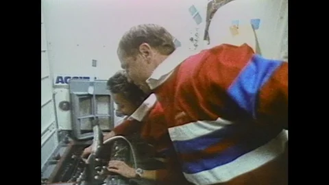 1980s: two astronauts working on a machine experiment in the space shuttle Stock Footage 109224900