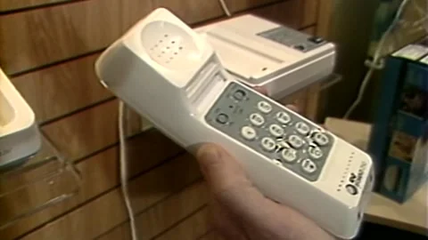 1980S WIRELESS TELEPHONE BEING PICKED UP INSIDE PHONE STORE 動画素材 319832276