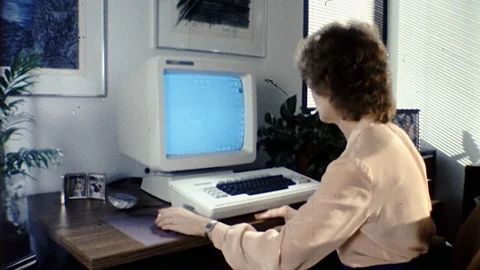 1980s Woman Puts Floppy Disk Computer Uses Mouse Monitor Vintage Old Film Movie Stock Footage