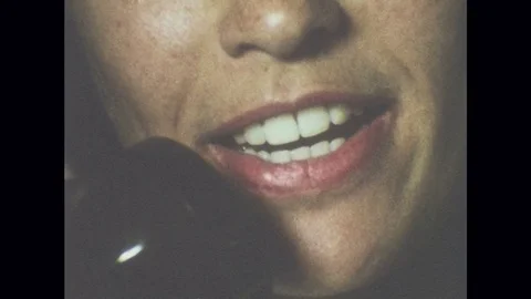 1980s: Woman's mouth speaking into phone receiver. Stock Footage