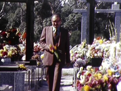 1982: Man Placing Flowers On  Grave (Archive Footage) Stock Footage 75465355