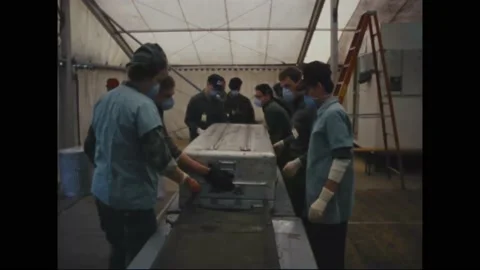 1983 - Doctors open a body bag to inspect the charred remains of a Marine killed Stock-Footage 234411976