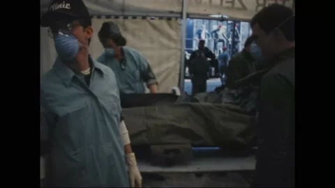 1983 - Doctors tag the charred corpses of Marines killed in the Beirut barracks Stock Footage 234411929