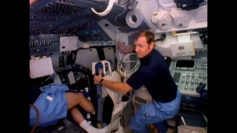 1984 - Pilot David Mathieson Walker is shown in the cockpit as astronauts work Stock Footage
