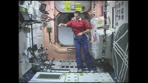 1990s: Astronaut plays with yo-yo in zero gravity on space station. 스톡 동영상 128213248