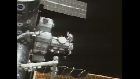 1990s: astronaut works on outside of space station above Earth. Space shuttle Stock Footage