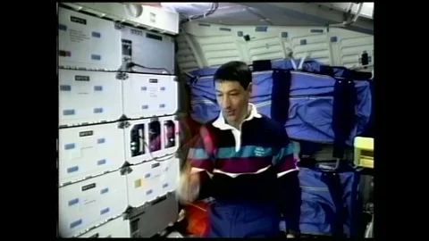 1990s: astronaut in zero gravity plays with clacker balls, releases them, they Stock Footage 129277857