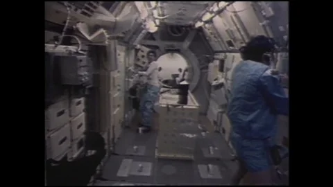 1990s: Astronauts work in space.  Man looks into machine.  Animation of Stock Footage 128006037