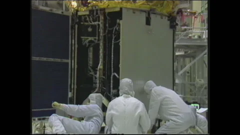 1990s: Engineers in protective suits assemble satellite in workshop. Stock Footage 146555084