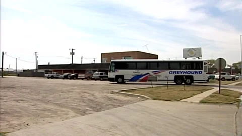 1990s GREYHOUND BUS PULLING UP TO A STOP IN RURAL TOWN Vídeos de archivo 313471136